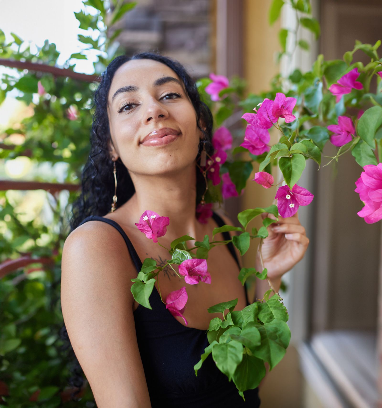 Ariana Hurtado of Womb Bloom smiling among pink bougainvillea